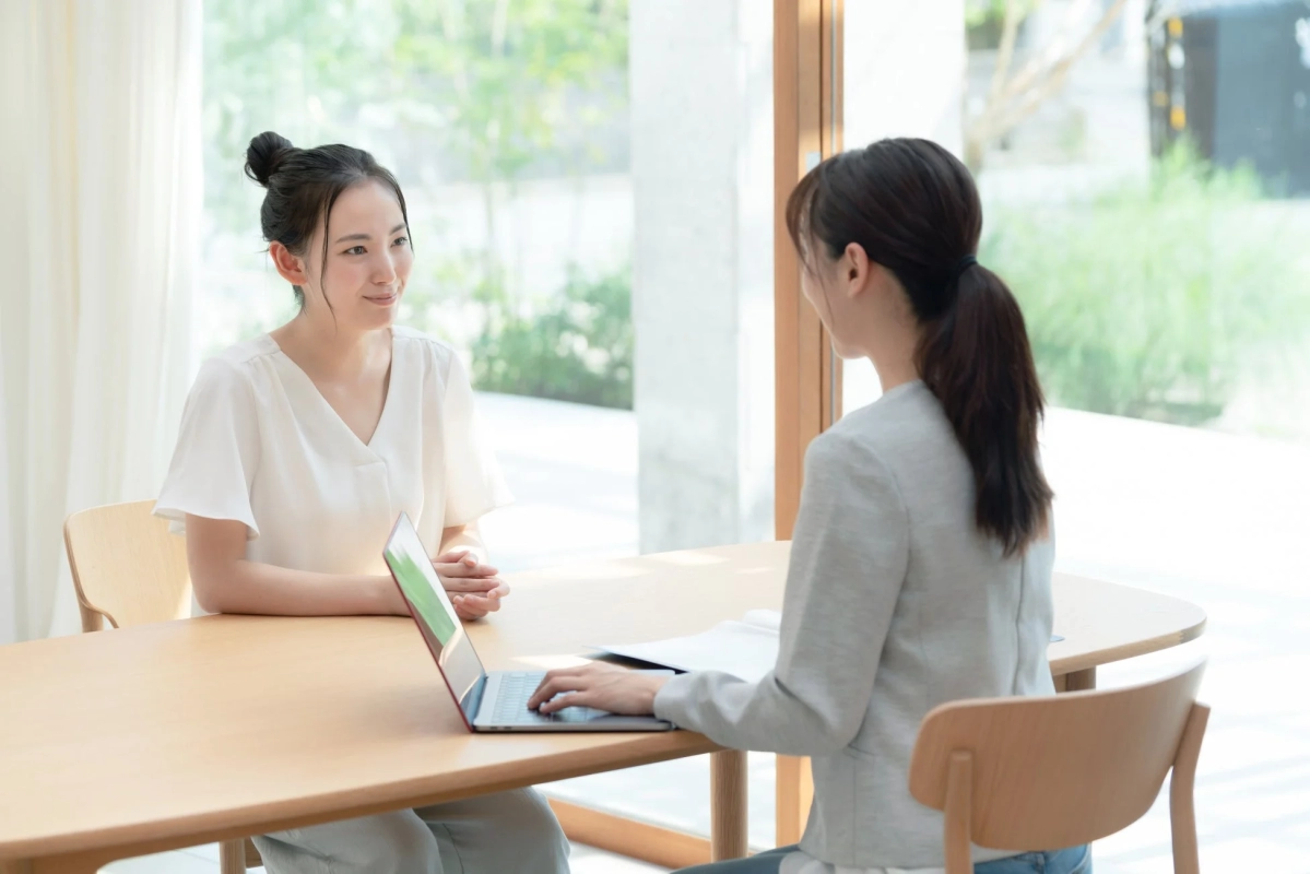 明るい窓際の空間で打ち合わせをする2人の女性