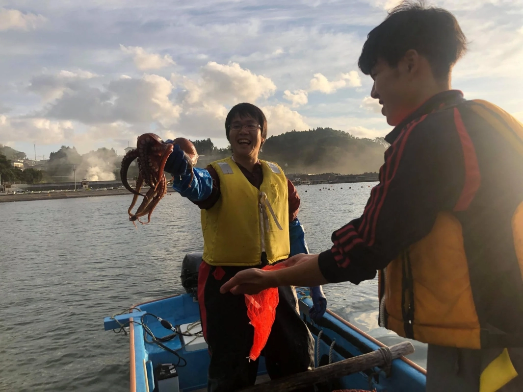 タコを抱える男性の笑顔